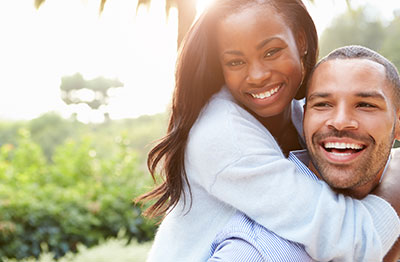 Happy man and woman showcasing their healthy smiles.